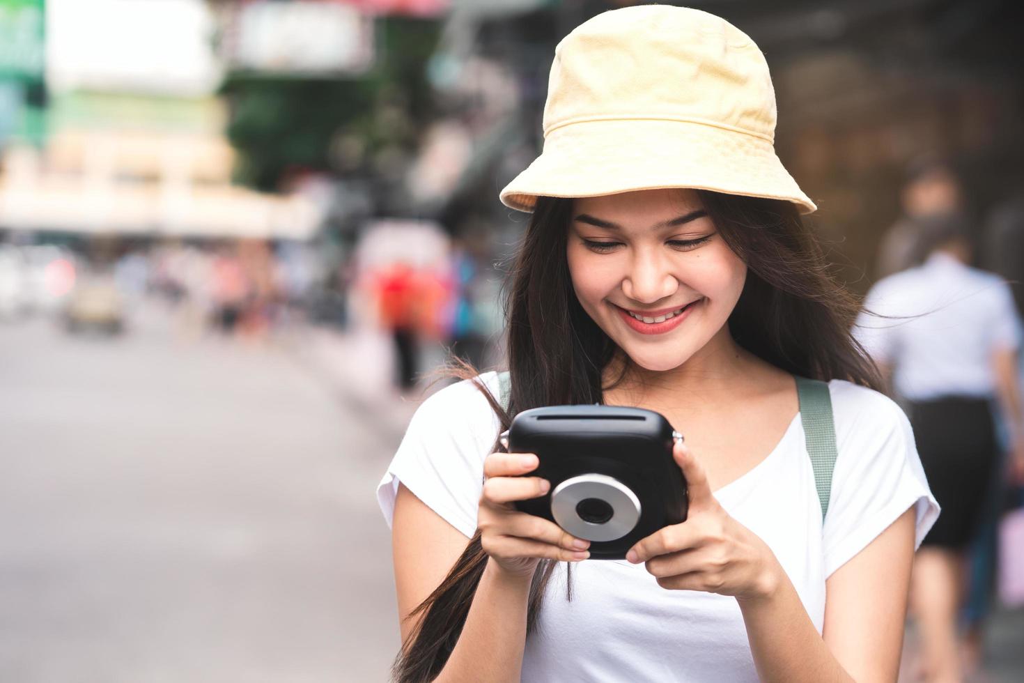 donna asiatica del viaggiatore con la macchina fotografica istantanea a khaosan foto