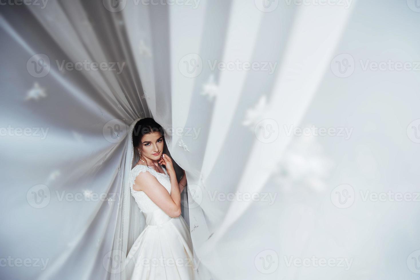 bella ragazza sposa su sfondo di tende alla finestra foto