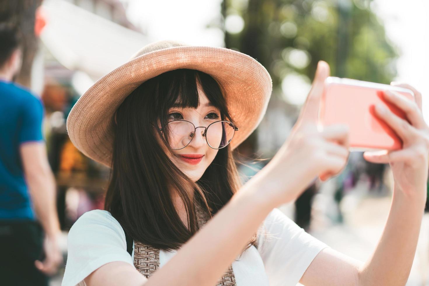 giovane ragazza asiatica di influenza che viaggia a Bangkok con lo smartphone per il caricamento sul social network. foto