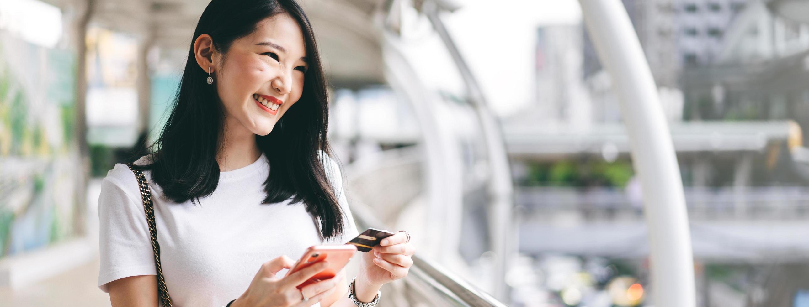 consumatore di donna asiatica di affari di giovani adulti che utilizza la carta creadit e lo smartphone per lo shopping online. foto