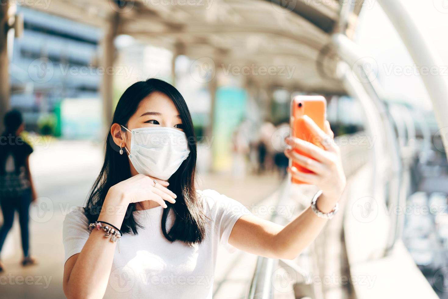 selfie giovani adulti affari asiatici donna che lavora indossare una maschera per proteggere il virus corona o covid19. foto