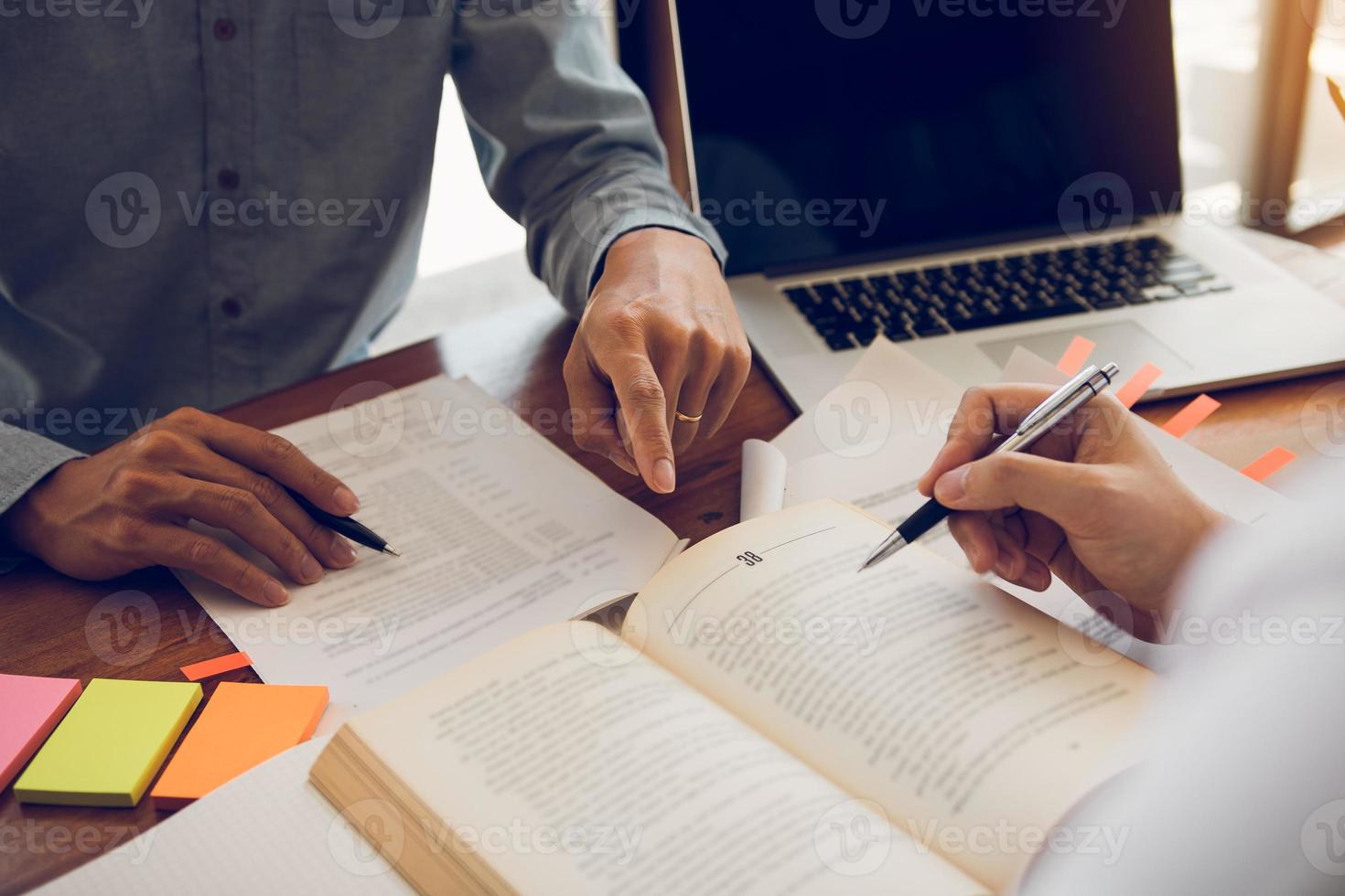 giovani studenti universitari asiatici che studiano insieme seduti alla scrivania in biblioteca. foto