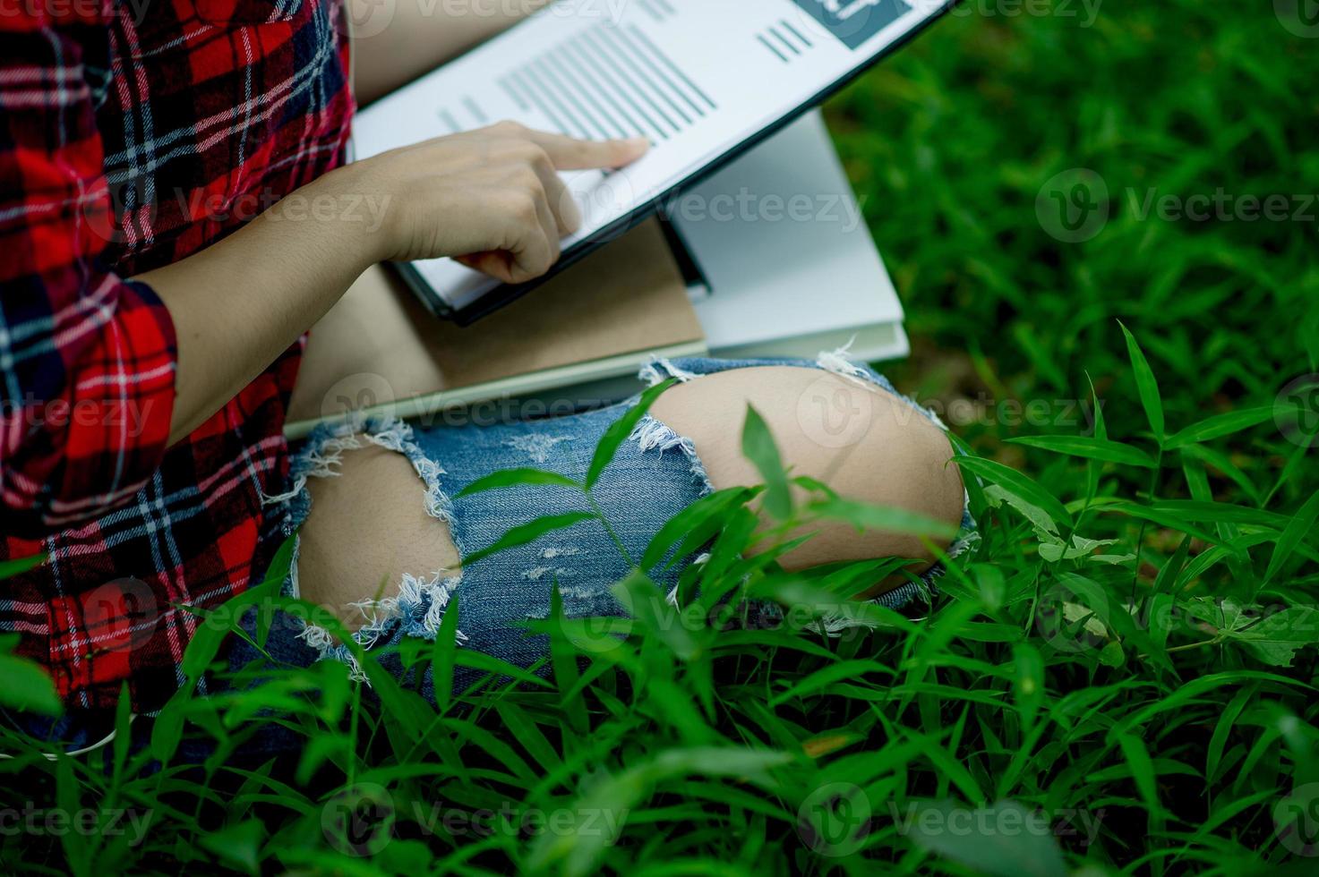 mano del personale, responsabile marketing che punta a documenti aziendali e seduto sotto l'albero - idee imprenditoriali foto