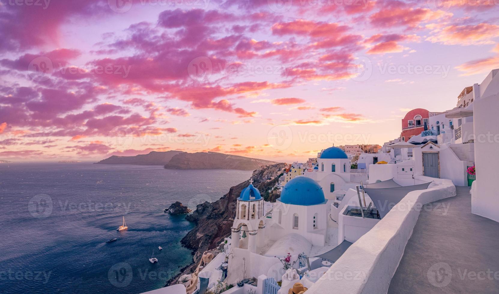 fantastico paesaggio al tramonto della famosa destinazione di viaggio e vacanza. concetto di avventura estiva di lusso. splendida vista sul villaggio di oia, santorini, grecia. hotel con piscine e architettura straordinaria foto