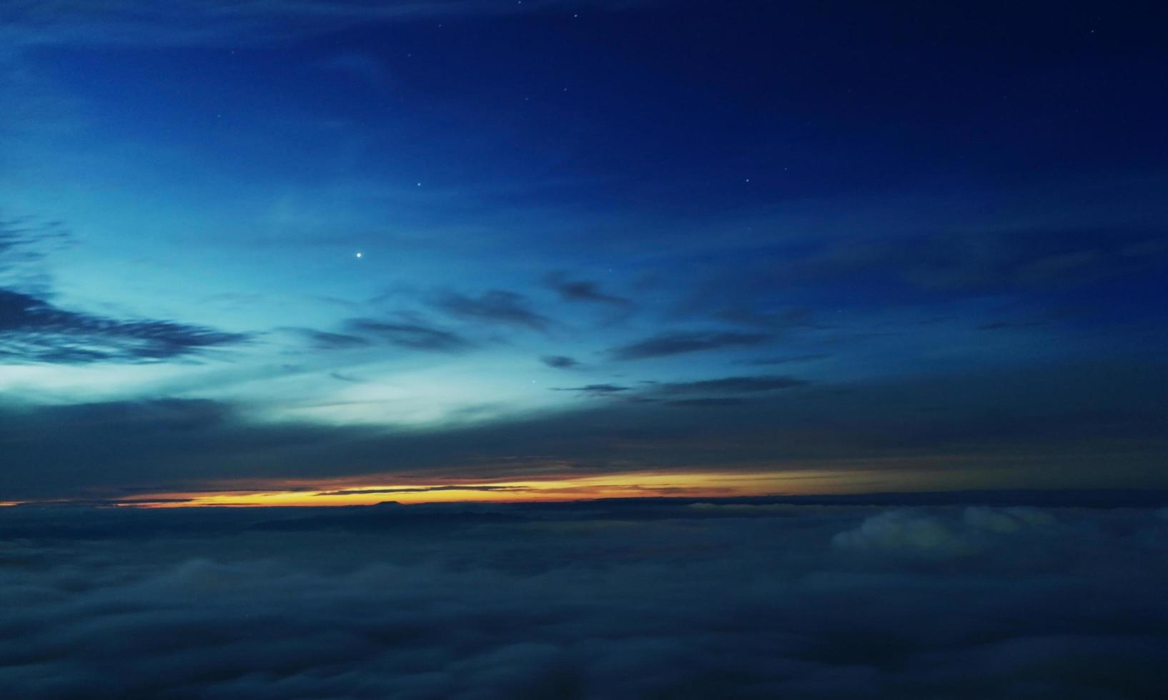 cielo mattutino prima dell'alba ci sono alcune stelle luminose. il cielo comincia a schiarirsi e c'è un mare di foschia sotto. phu thap boek, thailandia, meta turistica alla fine della stagione delle piogge foto