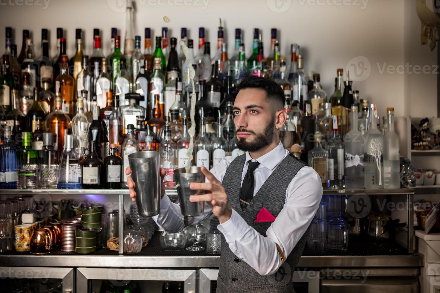 barman professionista con shaker che prepara bevanda alcolica foto