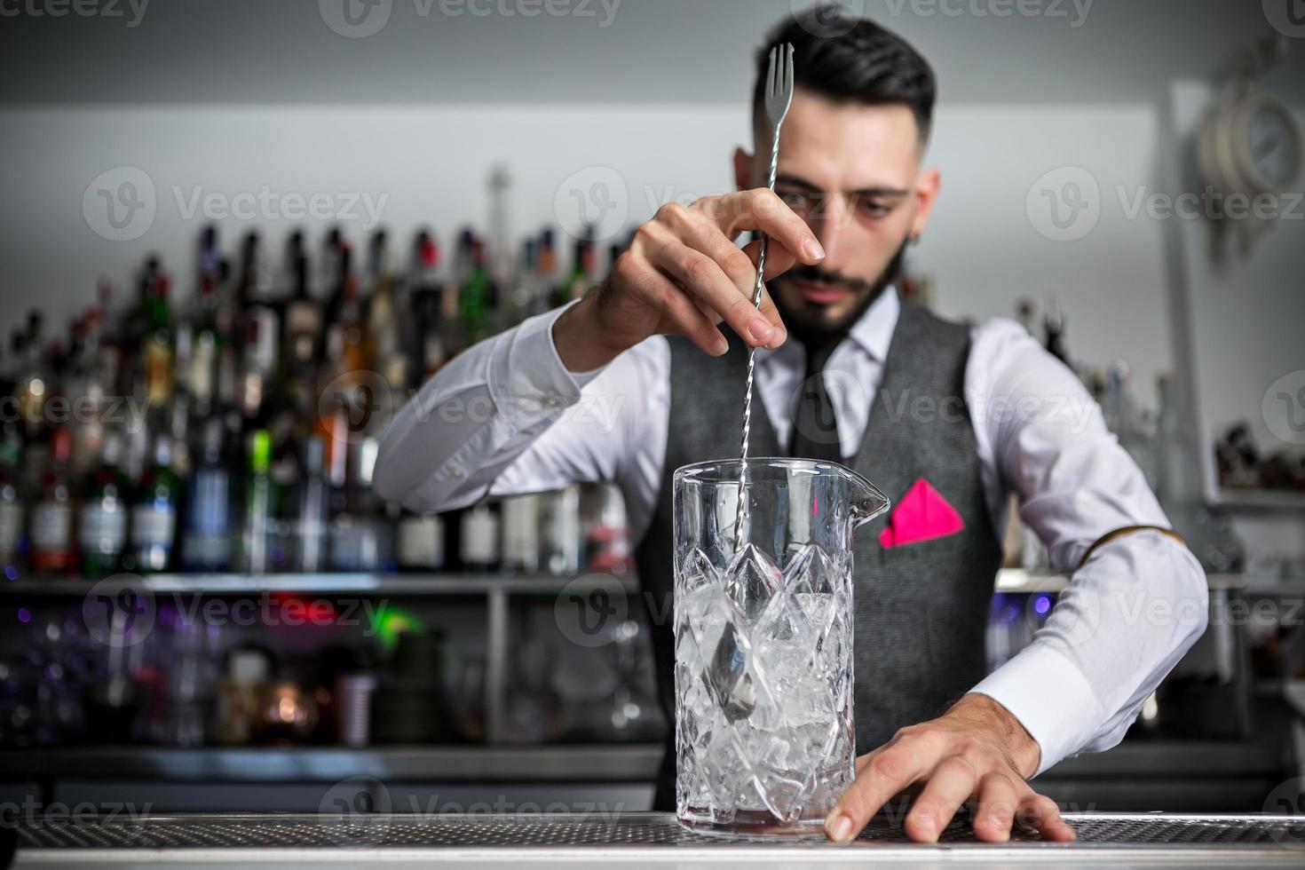 barista che mescola cocktail in vetro foto