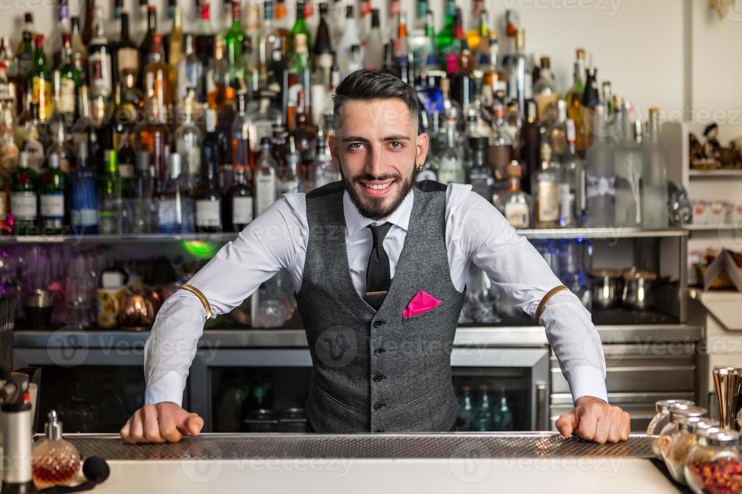 barista positivo in piedi al bancone foto