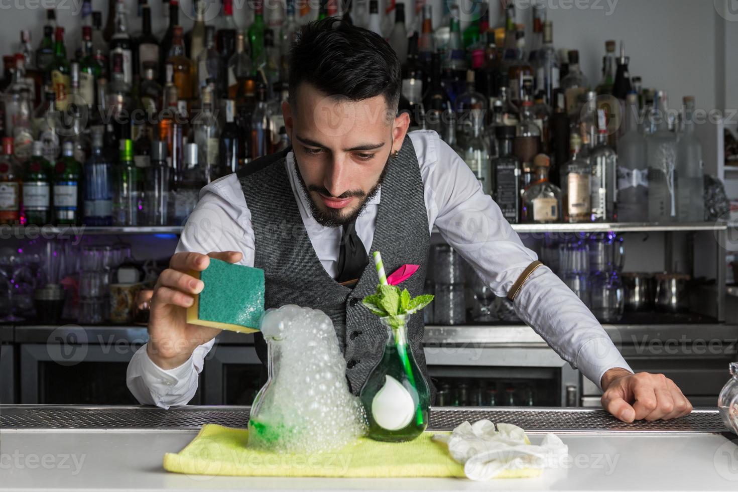 mixologist che fa cocktail molecolare al bar foto