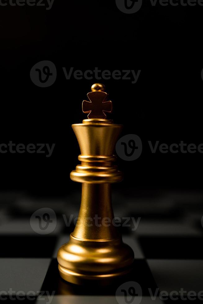 re degli scacchi d'oro in piedi da solo sulla scacchiera foto
