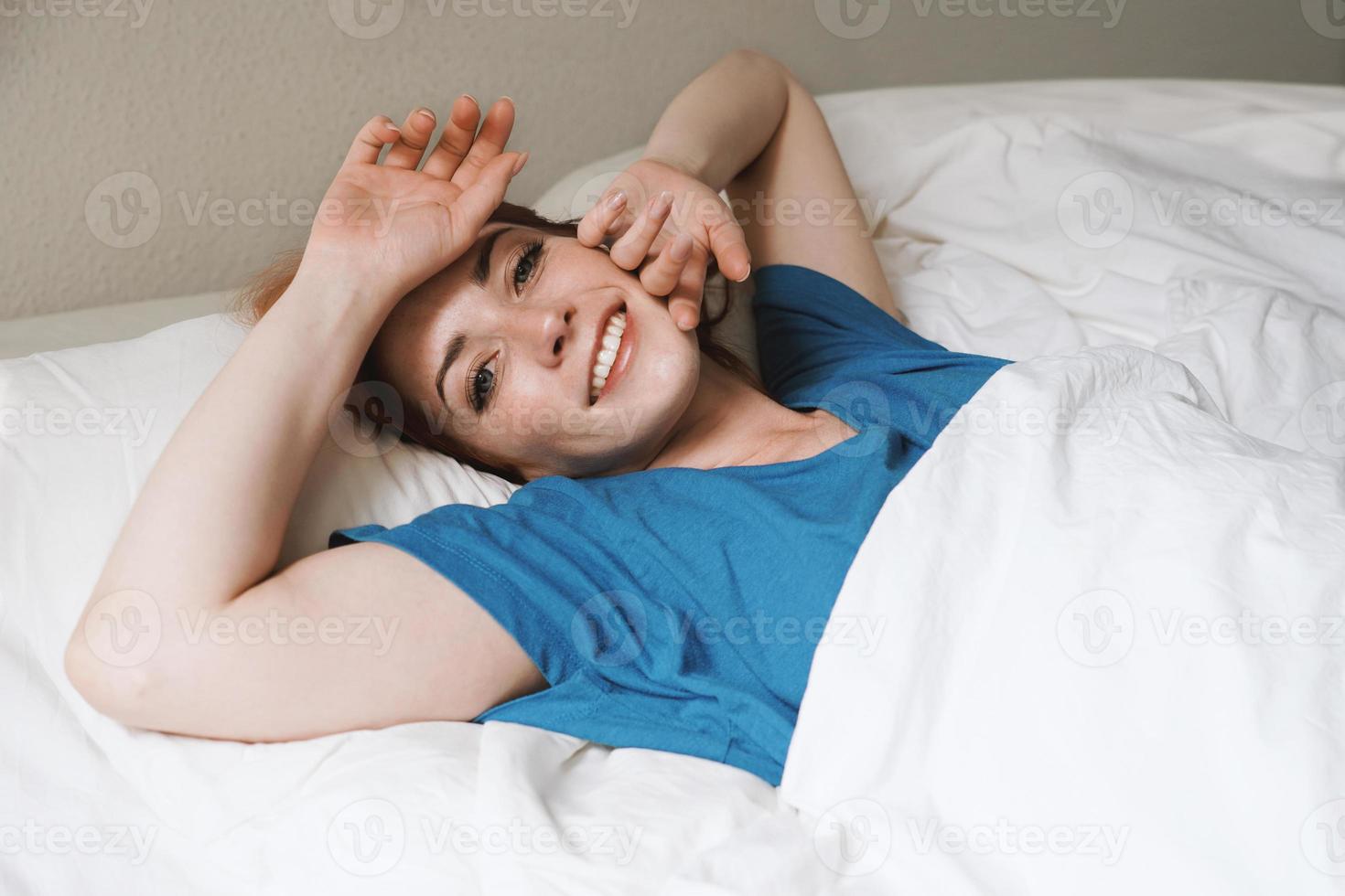 alzarsi e splendere - giovane donna riposata a letto svegliarsi sorridente foto
