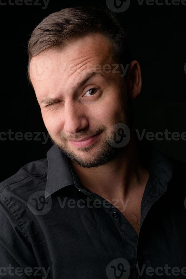 ritratto in studio di un giovane uomo caucasico in un blazer nero, guardando la telecamera, in piedi su sfondo semplice studio foto