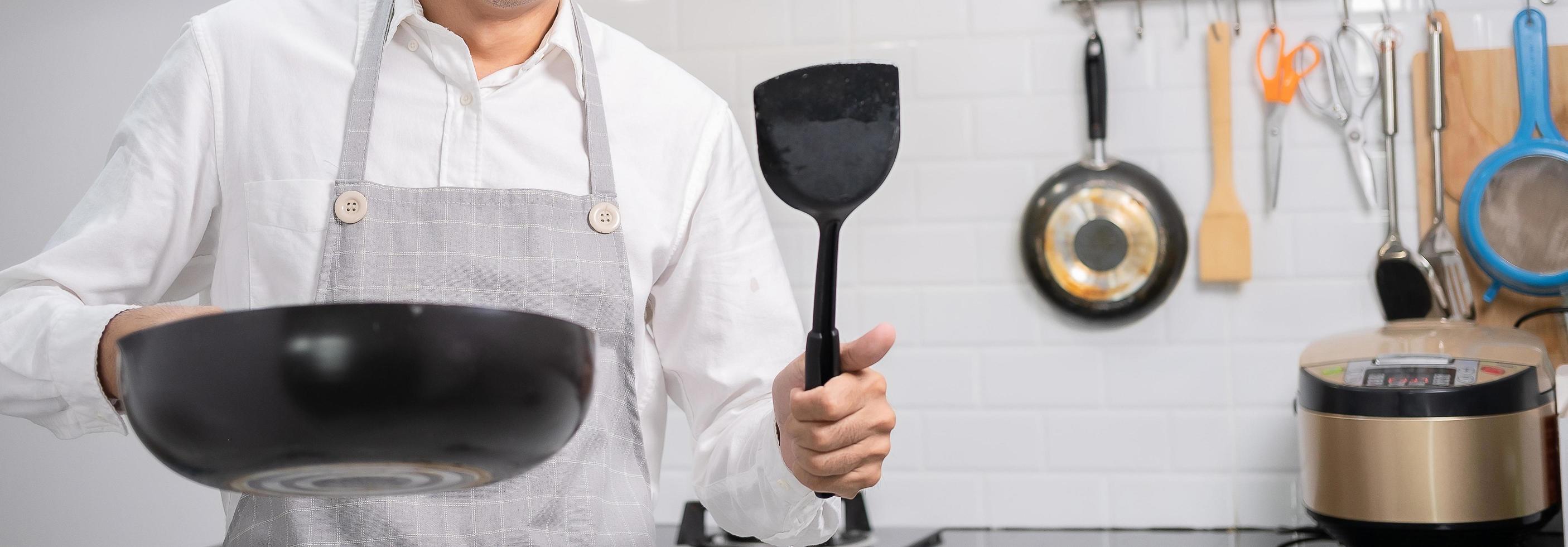 chef asiatico uova fritte in padella al cibo tailandese in cucina sul fornello a gas l'olio in padella bollente.uova e carne di maiale cotta. prima di servire alla famiglia felice per mangiare insieme a casa foto