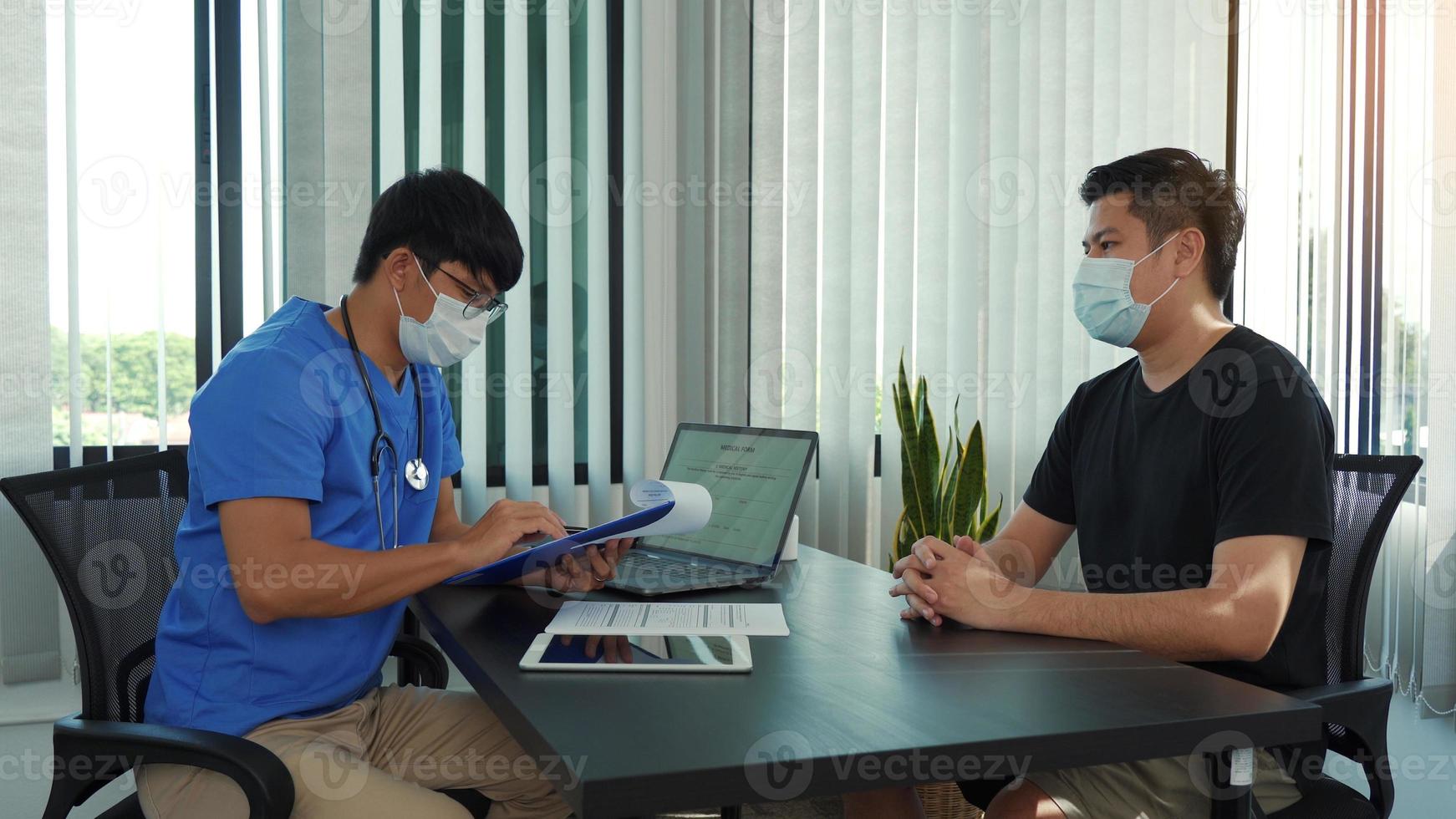 i medici spiegano il trattamento della malattia di un paziente mentre indossano una maschera durante l'epidemia. foto