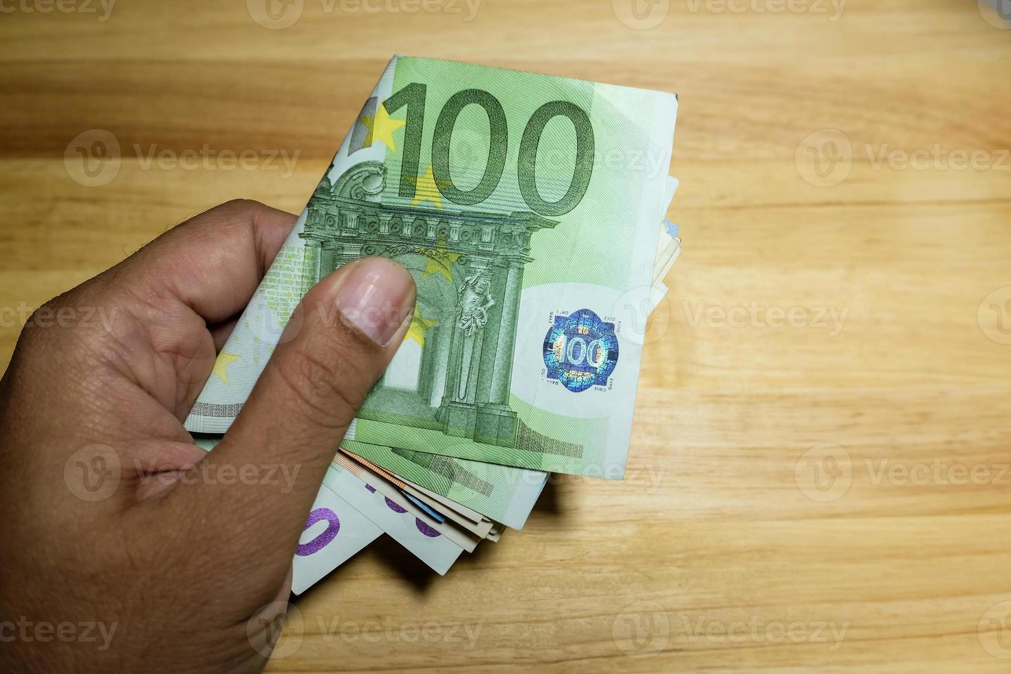 mano maschio che tiene le banconote in euro foto