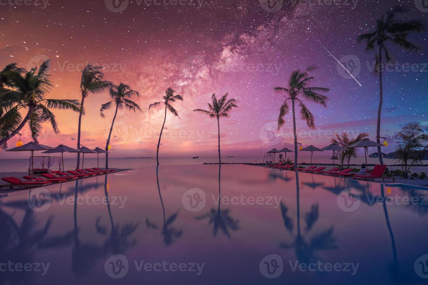 lussuosa piscina a sfioro tramonto, cielo notturno, via lattea. resort estivo sulla spiaggia in un paesaggio tropicale. atmosfera tranquilla vacanza al mare vacanza. incredibile vista sulla spiaggia al tramonto dell'isola, piscina di palme foto