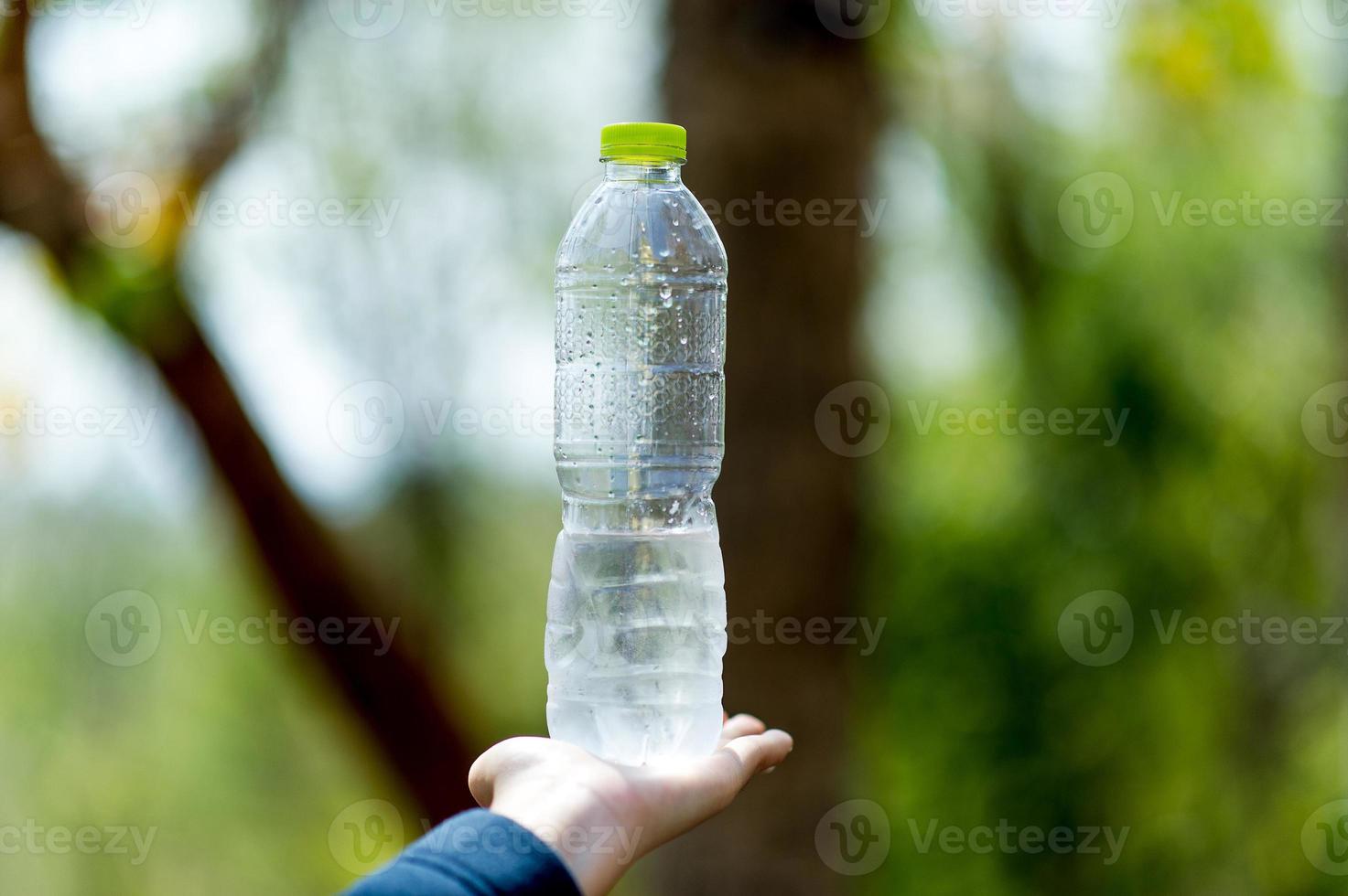 concetto creativo dell'acqua potabile della bottiglia d'acqua e della mano con lo spazio della copia foto