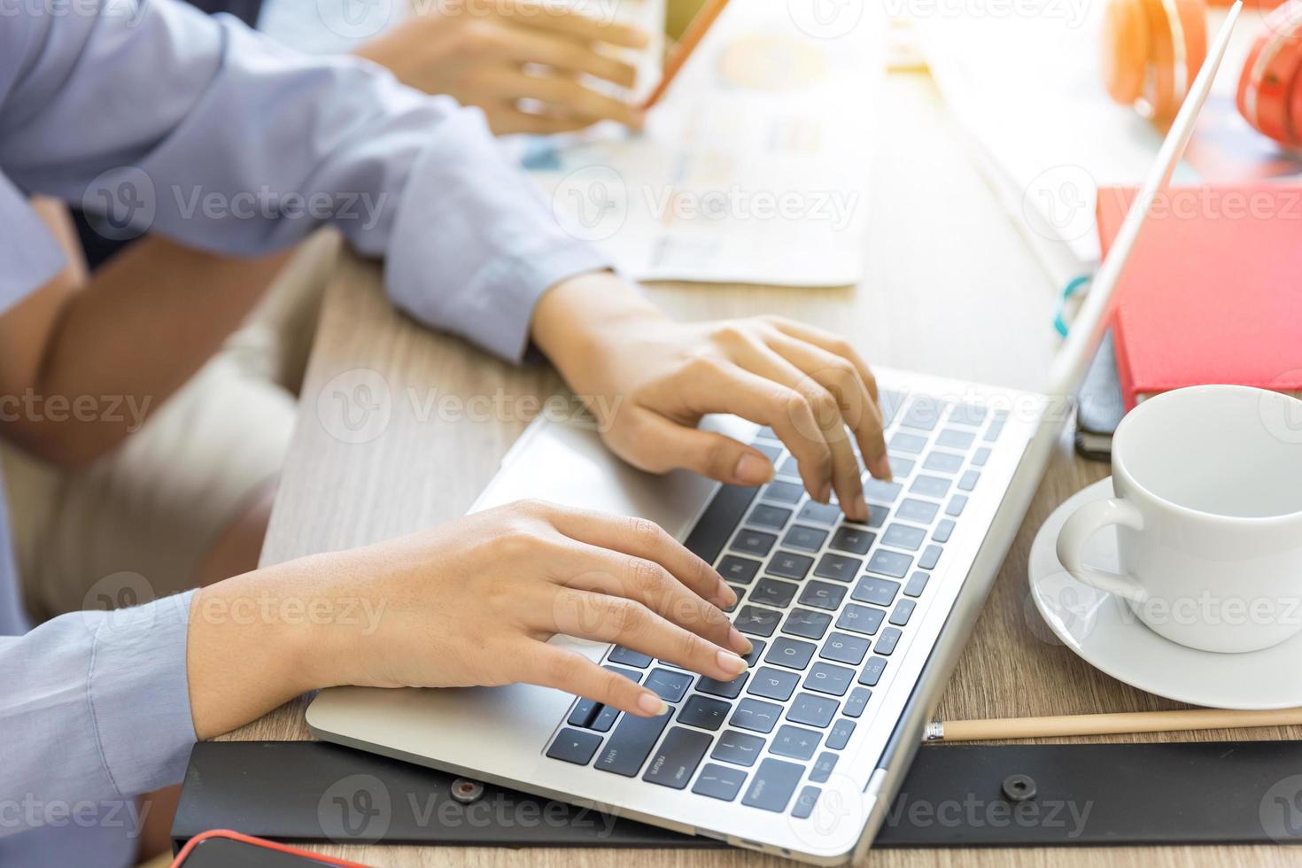 le mani di una donna stanno usando un computer portatile per lavorare a casa. lavorare da casa o lavorare a casa concetti. foto