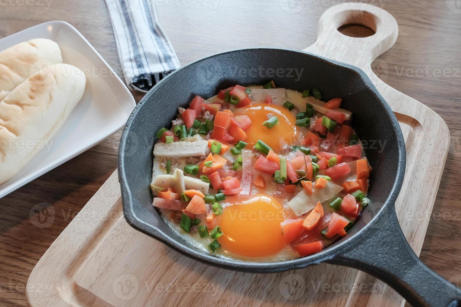 uova fritte in padella con carne di maiale e tutte le verdure su tavola di legno. è in stile vietnamita e popolare nel sud-est asiatico. foto