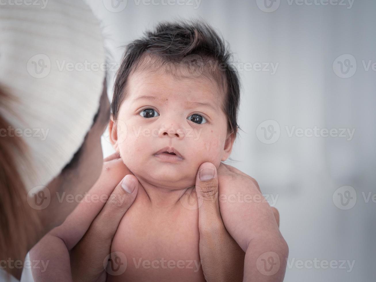 ritratto di tre settimane di neonato asiatico australiano o neonato sdraiato sul letto bianco e aprendo gli occhi. foto