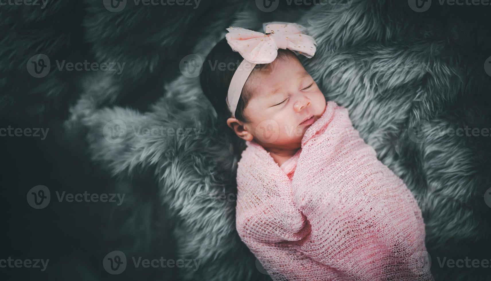 bambina asiatica che dorme sul letto. ritratto bambina studio illuminazione sul letto di pelliccia. concetto di famiglia del bambino foto