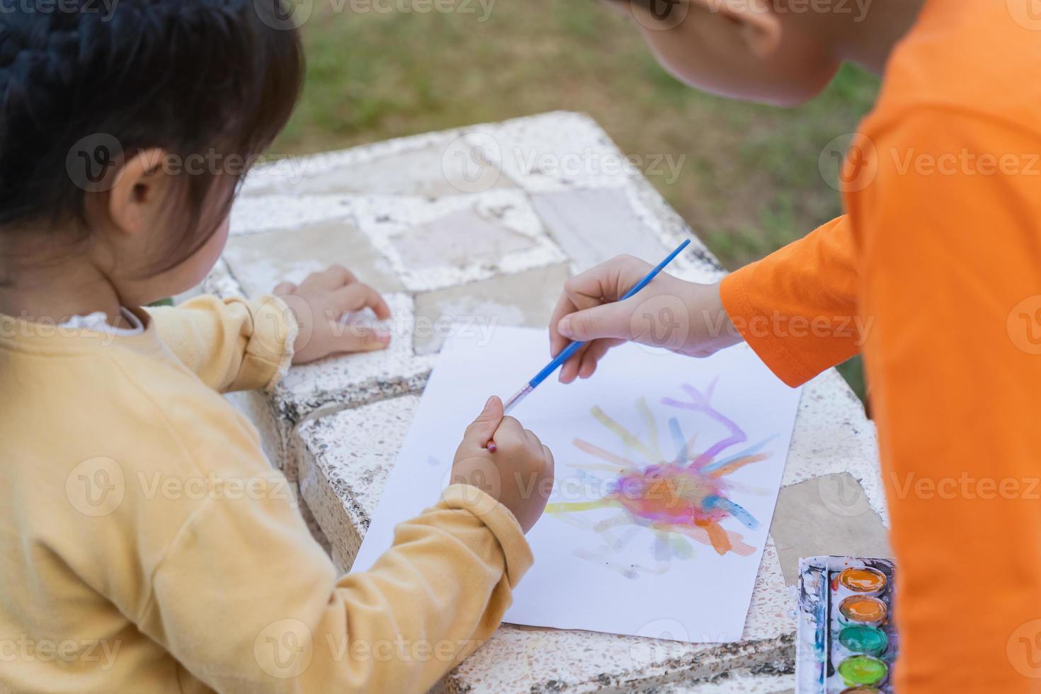 carino bambino dipinto con vernici colorate. ragazza asiatica che usa il concetto di stile di vita di attività di color.baby del disegno del pennello foto