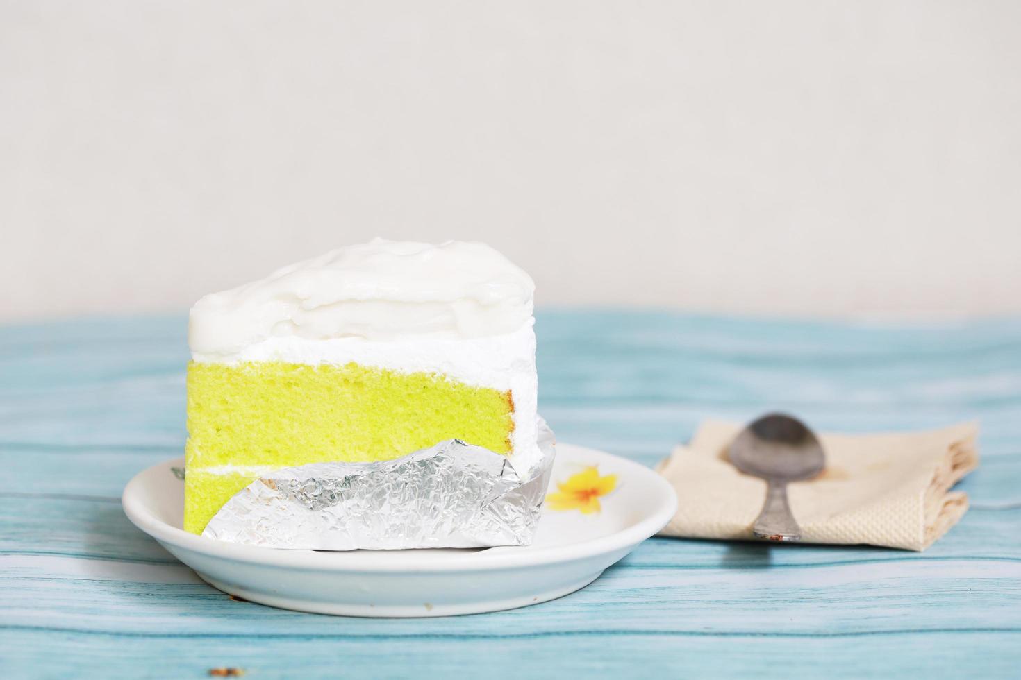 torta di crema di cocco sul tavolo blu dessert fatto in casa con cucchiaio e carta velina foto