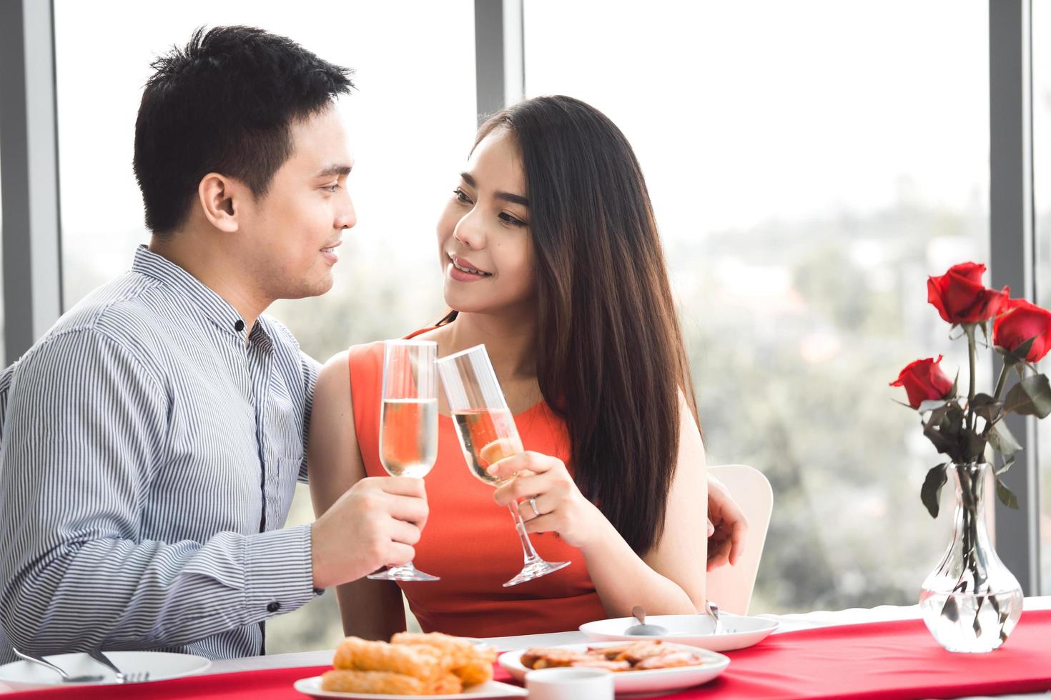 sorriso adulto asiatico coppia uomo e donna tenere in mano una bevanda champagne vicino a una finestra. foto