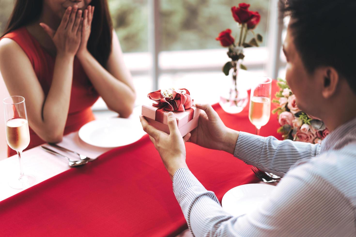 la coppia dell'uomo tiene in mano un regalo romantico rosso regalo regalalo alla ragazza. foto