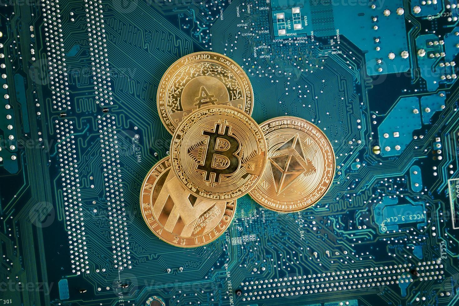 monete bitcoin, ethereum, litecoin e cardano su circuito elettronico blu foto