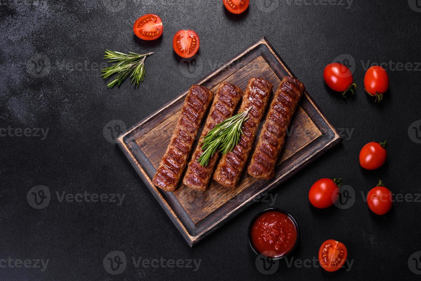 kebab alla griglia con spezie ed erbe aromatiche su fondo di cemento scuro foto