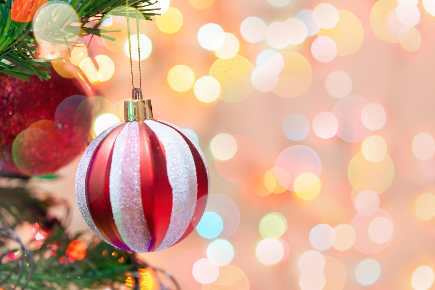 decorazione natalizia. palline rosse appese su rami di pino ghirlanda di albero di natale e ornamenti su sfondo bokeh astratto con spazio di copia foto