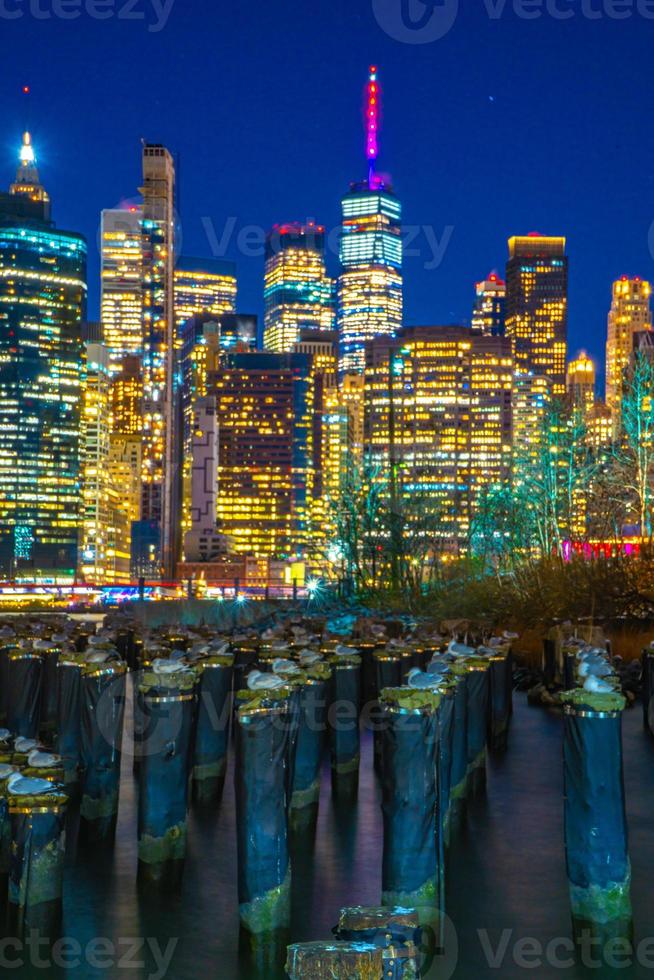 vista notturna dello skyline di new york presa dal parco del ponte di brooklyn foto