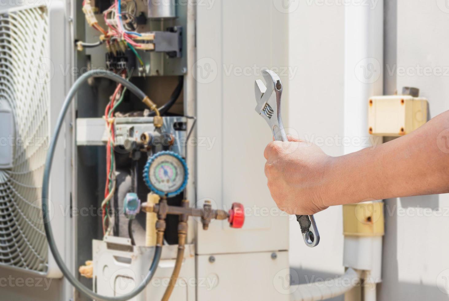 tecnico man mano che tiene una chiave inglese su aria condizionata moderna offuscata, manutenzione e concetto di riparazione foto