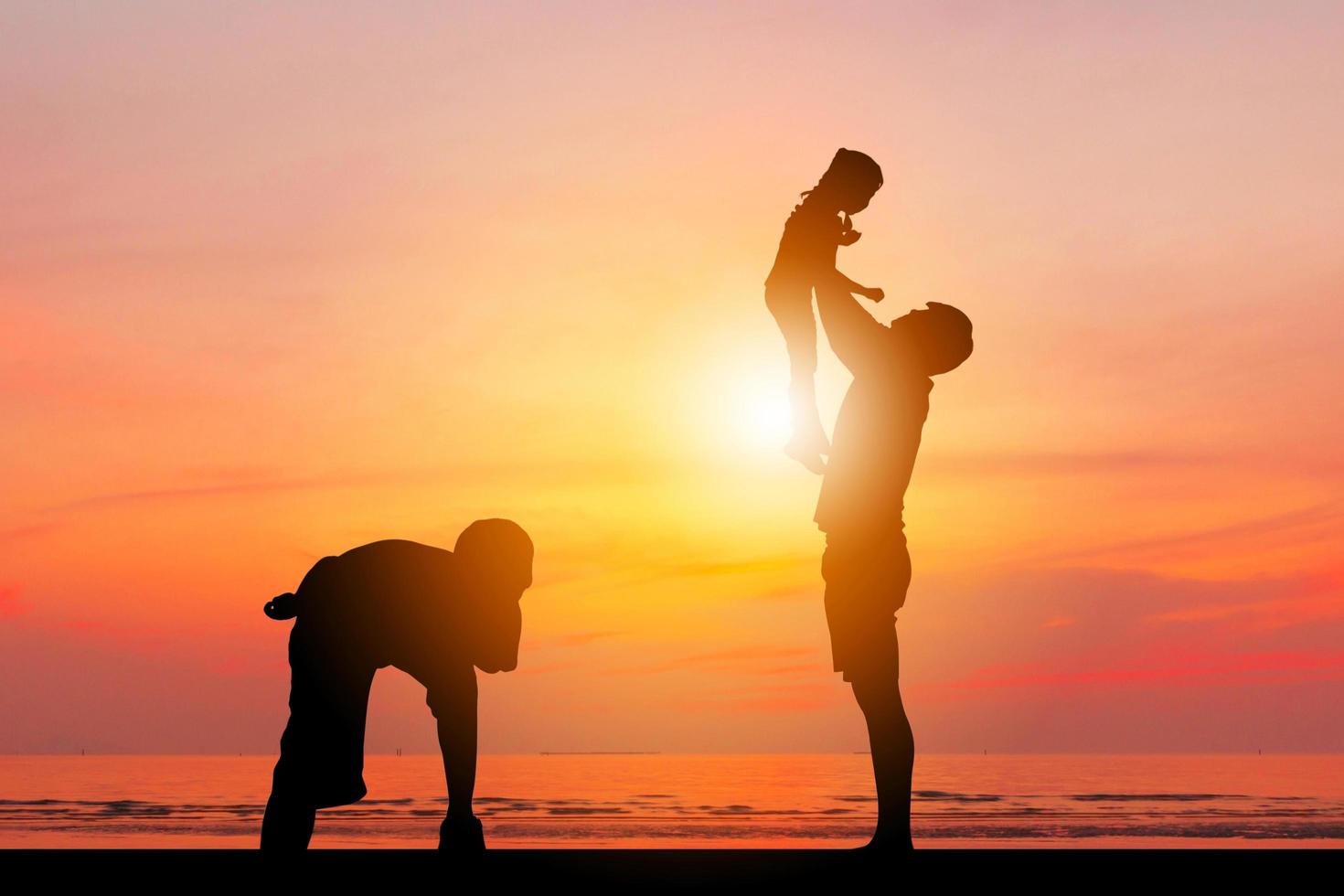 silhouette di padre e due bambini che si divertono al tramonto, concetto di famiglia felice. foto
