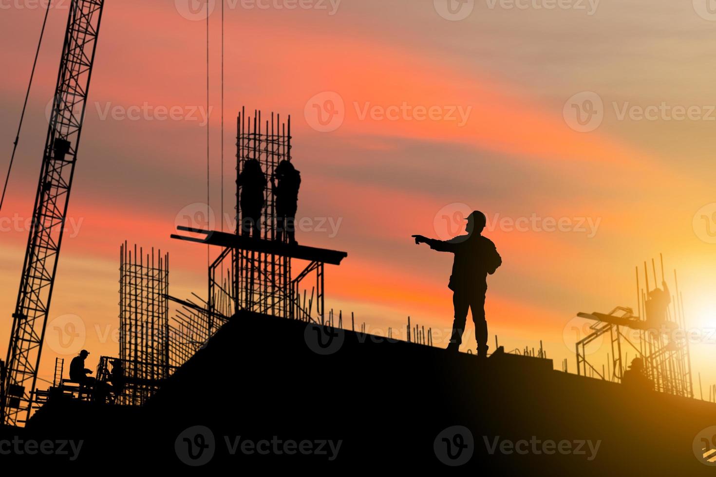 sagoma di ingegnere e lavoratore in cantiere, cantiere al tramonto in serata foto