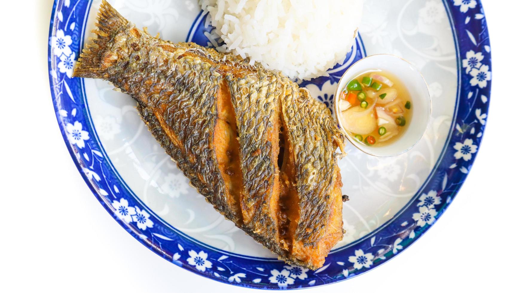 pesce tilapia fritto servito con riso al gelsomino e salsa di pesce al peperoncino tailandese, phrik nam pla. foto