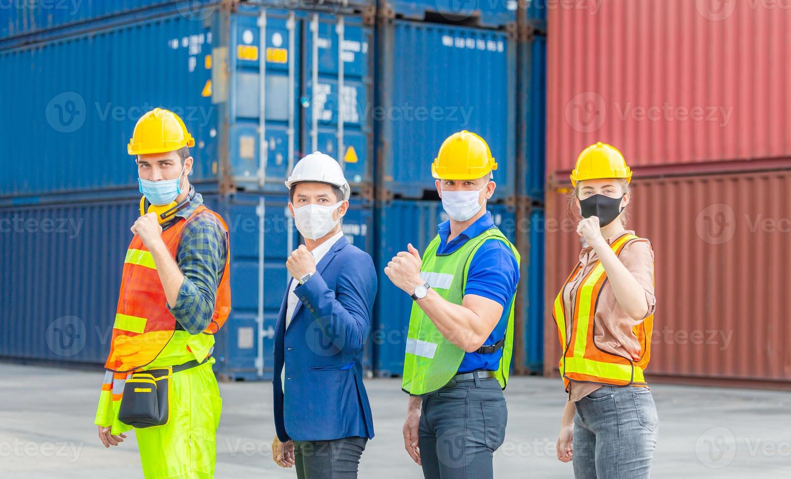 team di ingegneri e lavoratori che indossano una maschera protettiva contro il coronavirus, celebrazione del team di uomini d'affari nei container foto