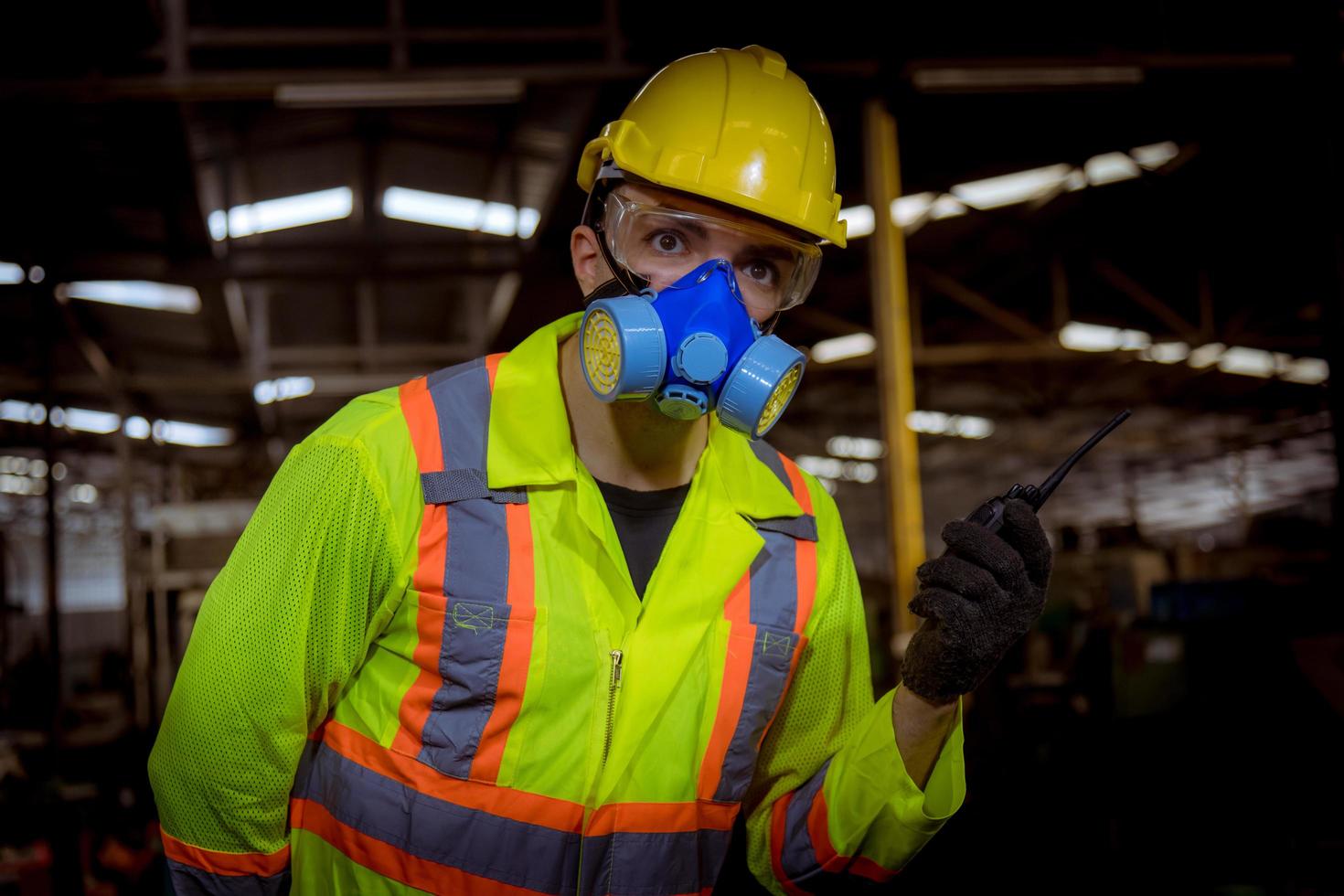 l'industria dell'ingegnere che indossa l'uniforme di sicurezza, i guanti neri, la maschera antigas si sente soffocare quando si controlla il serbatoio chimico nel lavoro di fabbrica dell'industria. foto