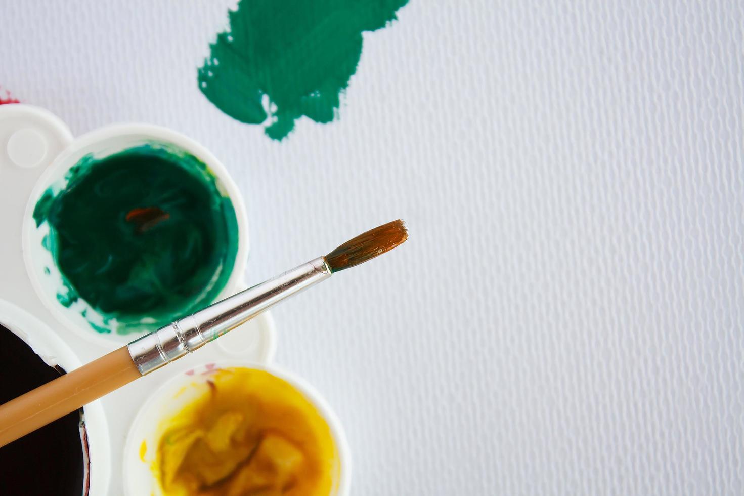 pennello con piastra a colori su carta per pittura ad acquerello foto