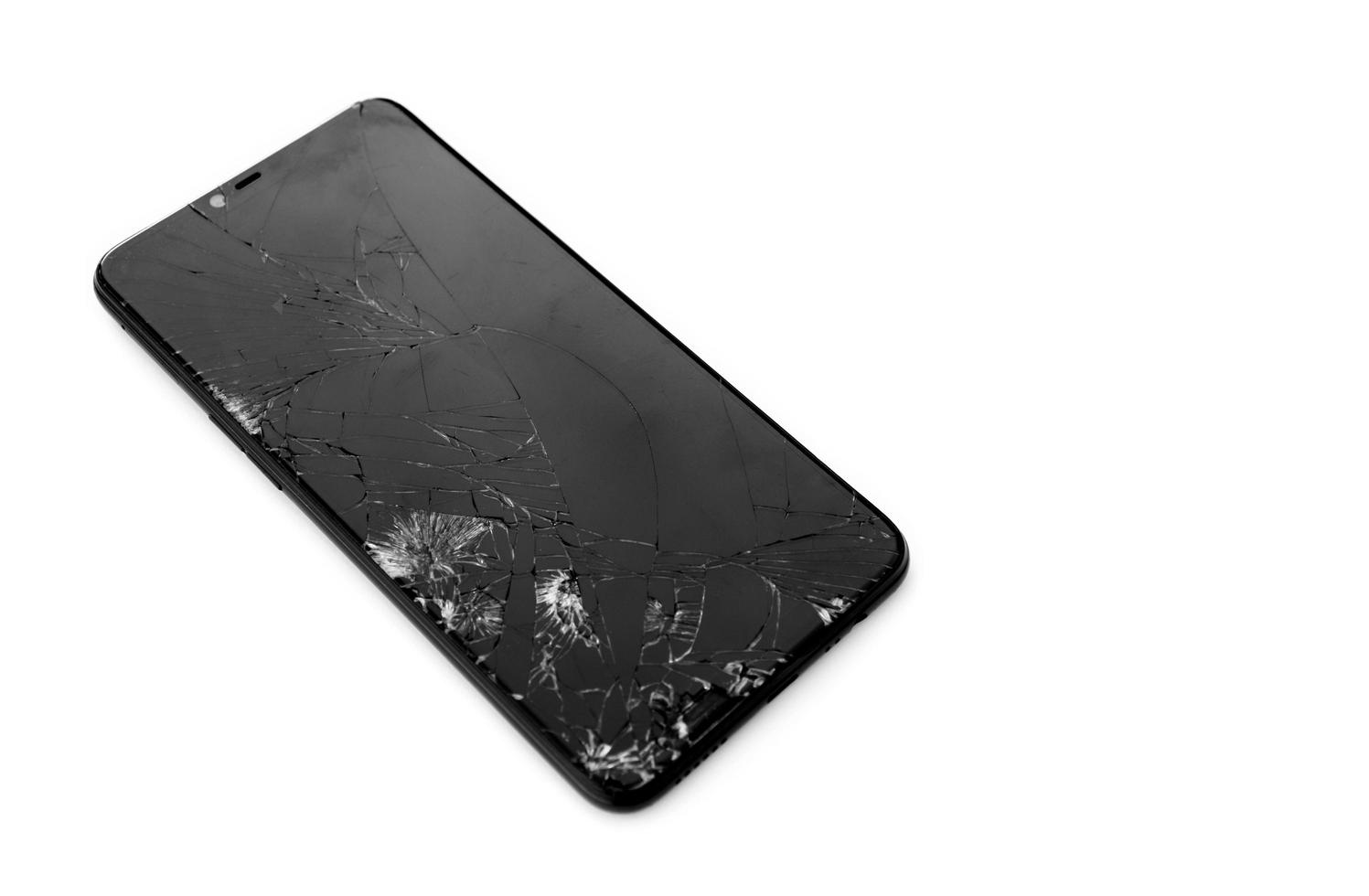 telefono cellulare touchscreen incrinato vista frontale su sfondo bianco, spazio per la copia, messa a fuoco morbida. foto