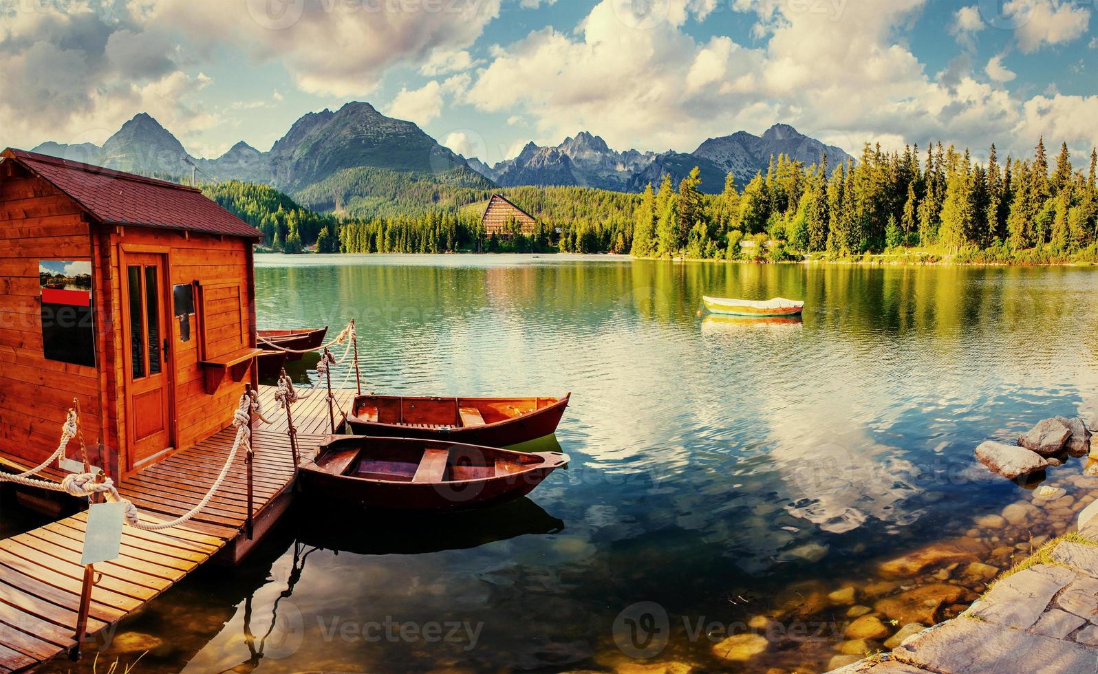 barca sul molo circondato montagne. fantastico shtrbske pleso foto