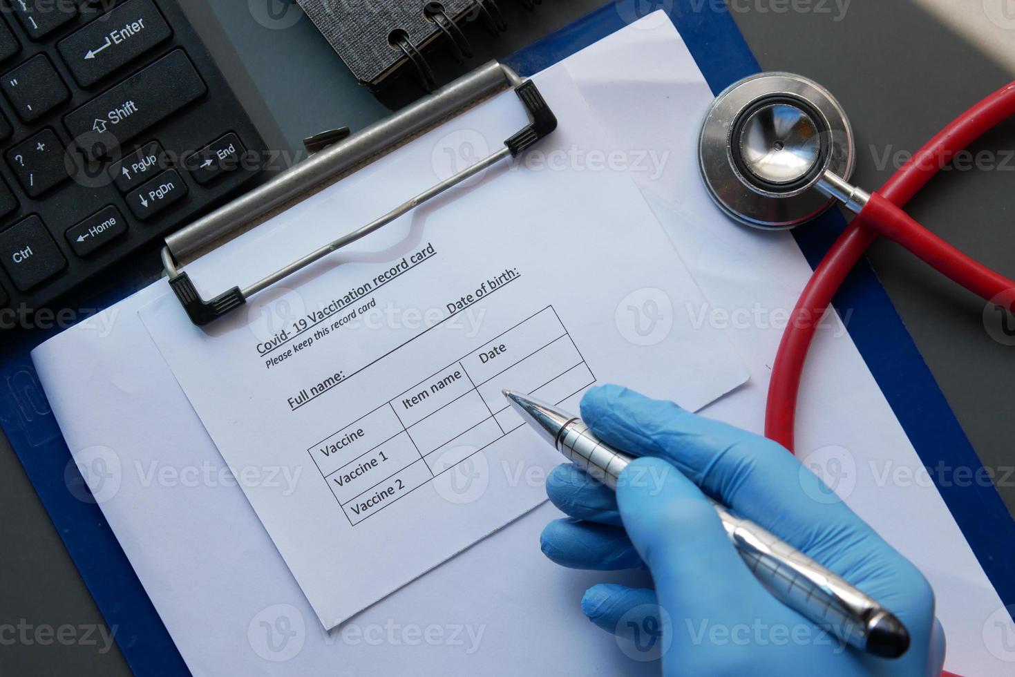 scheda di registrazione delle vaccinazioni, disinfettante per le mani e maschera su sfondo colorato foto