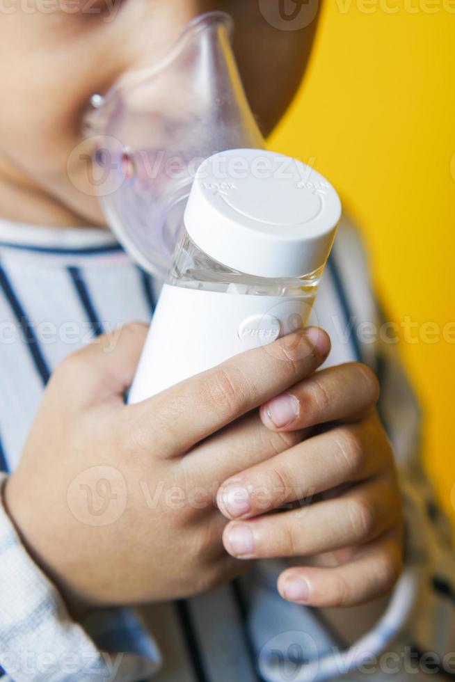 bambina che usa un nebulizzatore da vicino foto