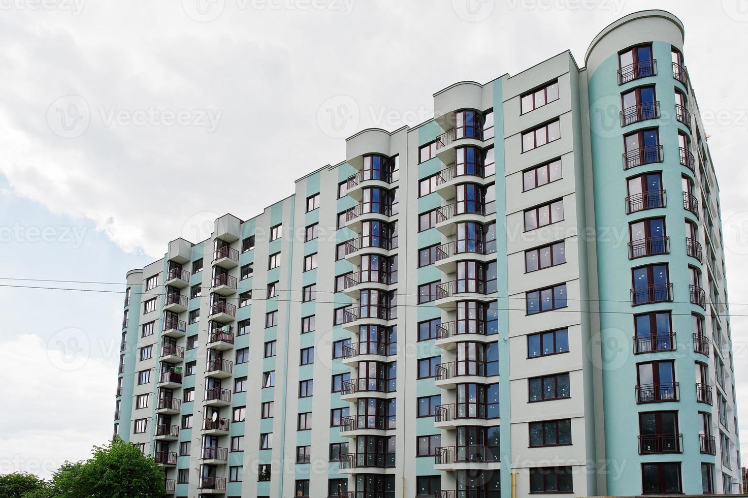balcone di un nuovo edificio residenziale moderno turchese a più piani casa in zona residenziale su cielo blu soleggiato. foto