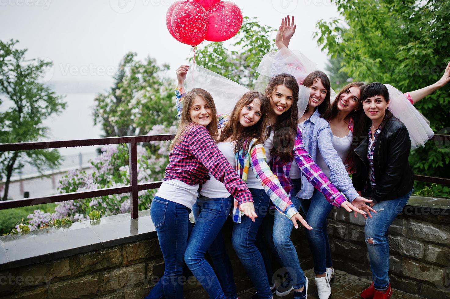 gruppo di sei ragazze che si divertono all'addio al nubilato, con palloncini sotto la pioggia. foto