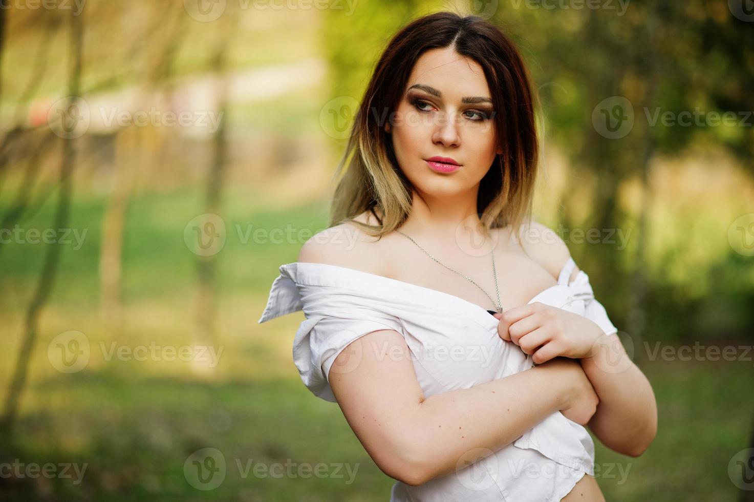 ritratto di ragazza con i capelli striati, indossata su camicetta bianca, che mostra le spalle. foto