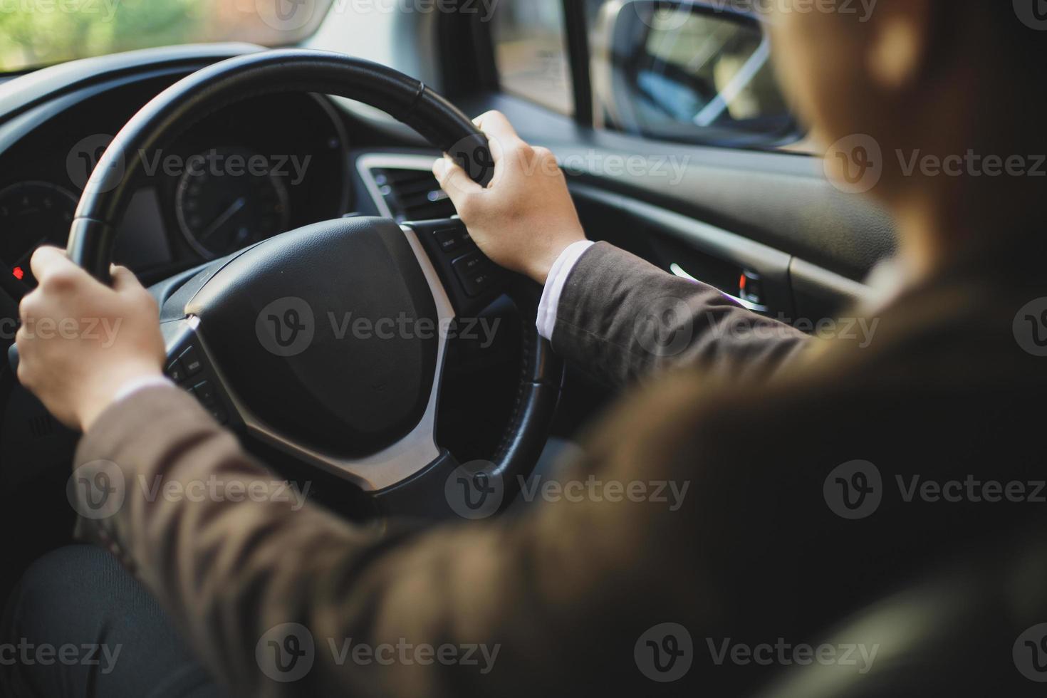 autista in tuta alla guida di un'auto con la mano sul volante foto