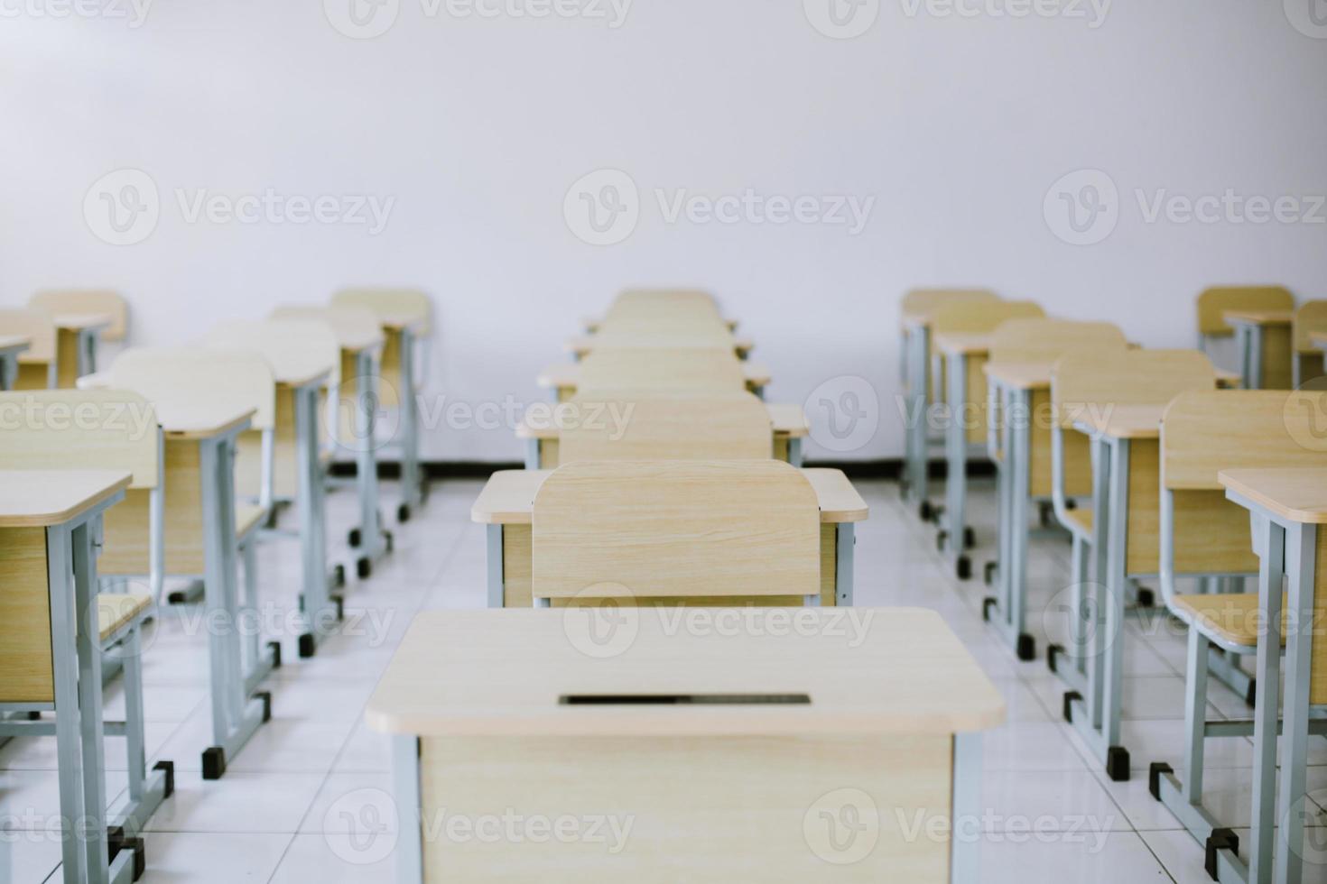 I banchi e le sedie degli studenti sono disposti ordinatamente in classe foto