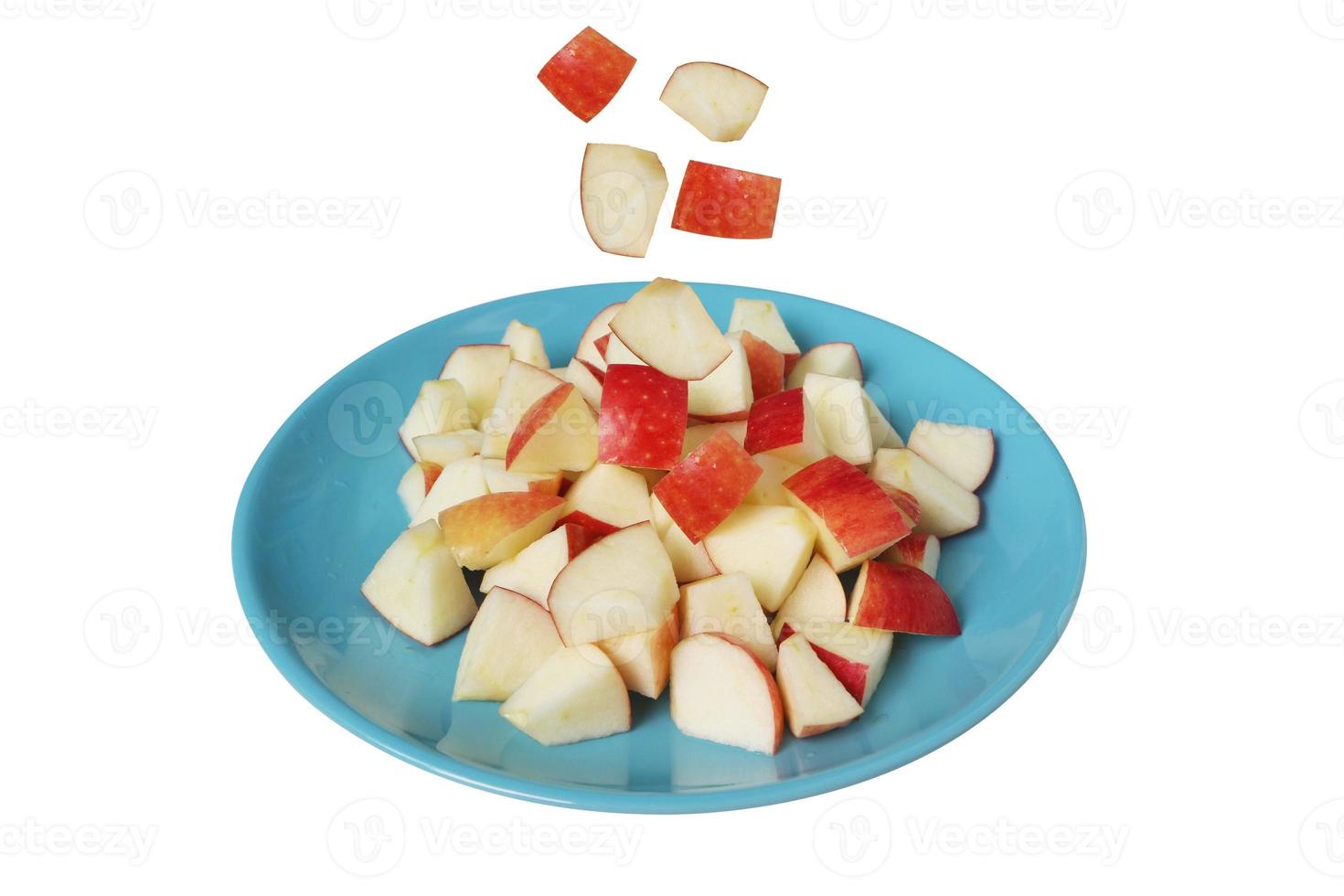 fetta di mela che cade sul piatto blu isolato su sfondo bianco con tracciato di ritaglio. foto